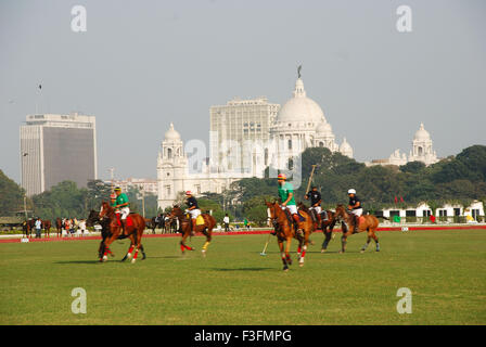 Players playing polo match on ground and Victoria memorial in background ; Calcutta ; West Bengal ; India Stock Photo