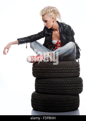 Punk girl sitting on tires. Stock Photo