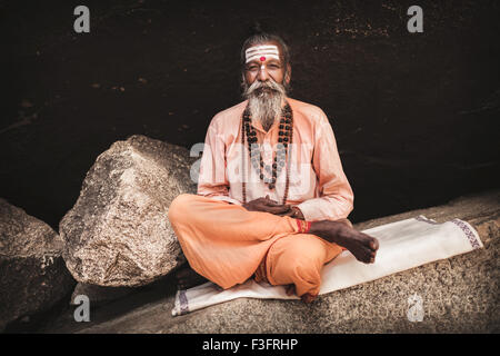 Hampi is a village in northern Karnataka state of India. Saint man at the sacred lake's site Stock Photo