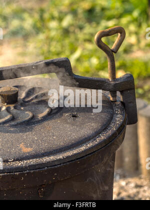 Black cast-iron kettle placed on fire Stock Photo