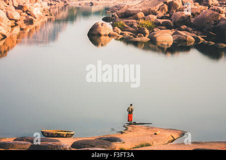 Hampi is a village in northern Karnataka state of India. Ablution in the morning on the sacred lake Stock Photo