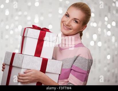 Smiling woman in cashmere sweater with gift boxes. Stock Photo