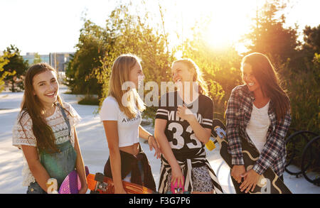 Four girls hanging out while talking and laughing Stock Photo