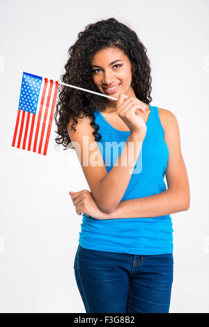 Portrait of a happy casual afro american woman holding USA flag isolated on a white background and looking at camera Stock Photo