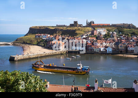 A modern dredger maneuvering in Whitby Lower Harbour, North Yorkshire, England, UK Stock Photo