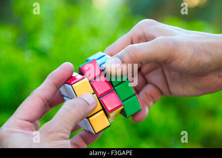 Concept ; Hand playing with Rubik puzzle cube game MR#201 Stock Photo