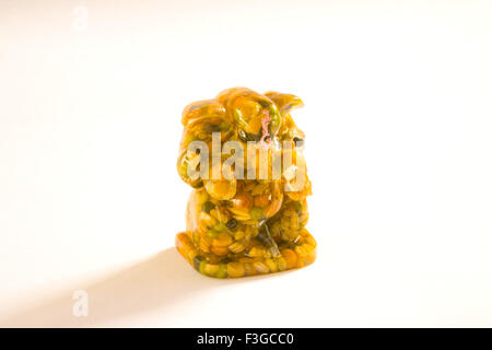 God Ganesha ganpati statue made from nine food grains and wax on white background ; India Stock Photo