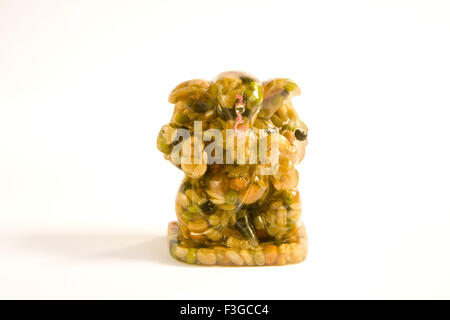 God Ganesha ganpati statue made from nine food grains and wax on white background ; India Stock Photo