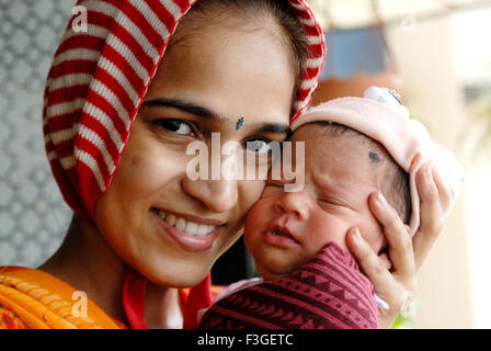 Indian new born baby with mother touching cheeks India MR#364 Stock Photo