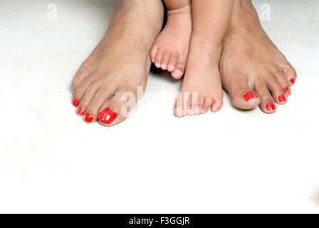 Feet foots legs of young baby child and adult woman mother legs comparison big and small - MR#152 - RMM 146939 Stock Photo