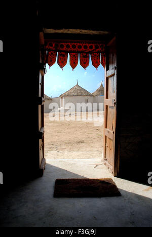 Kuba Kutchi Hut through wooden door in Gujarat Tourism ; Tarnetar Fair ; Gujarat ; India Stock Photo