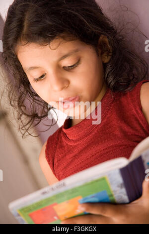 South Asian Indian eight years old girl Sanchi Pande studding at home ; Mumbai Bombay ; Maharashtra ; India MR#202 Stock Photo