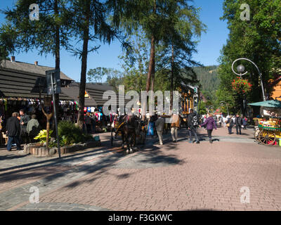 View down famous Krupowki Street Zakopane popular resort  Southern Poland on lovely autumn September day horse drawn carriages tourist transport Stock Photo