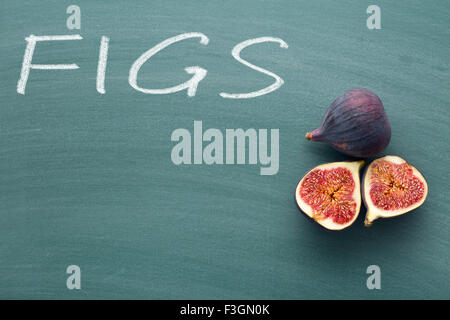 sliced fresh figs on green chalkboard Stock Photo