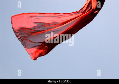 Abstract Indian traditional ladies wear saree red color flying air against blue skies o wind while hanging drying wash Pune Stock Photo