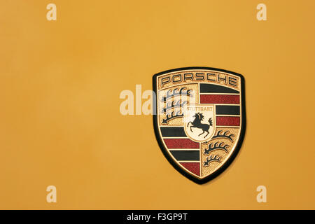 Emblem of new Porsche car with yellow colored bonnet Stock Photo