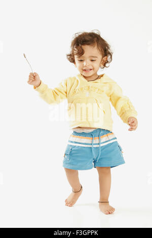 Marwari one year old boy in blue shorts and lemon yellow top playing MR#686P Stock Photo