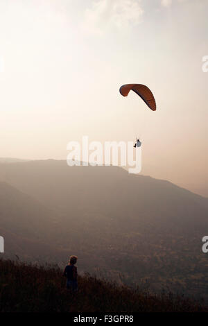 Paraglider flying high in sky enjoying ; Panchgani ; Maharashtra ; India Stock Photo