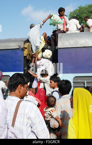 Old man trying to climb on roof of train on railway station ; Jodhpur ; Rajasthan ; India Stock Photo