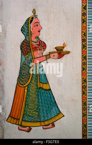 Wall painting depicting lady walking with light called diya in her palms ; Nathdwara ; Rajasthan ; India Stock Photo