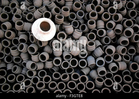 White raw earthen water pot kept on several other small pots after making ; Pune ; Maharashtra ; India Stock Photo