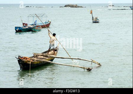 Boat man paddling his boat in Arabian sea ; district Sindhudurga ; Maharashtra ; India Stock Photo