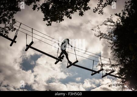 Mature man, high rope walking, low angle view Stock Photo