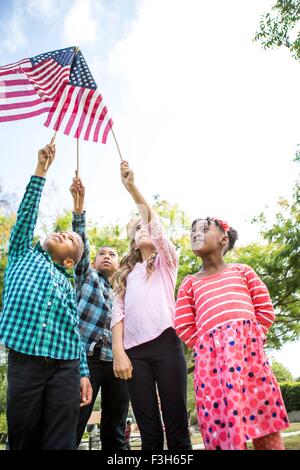 Children holding up American flags in park Stock Photo