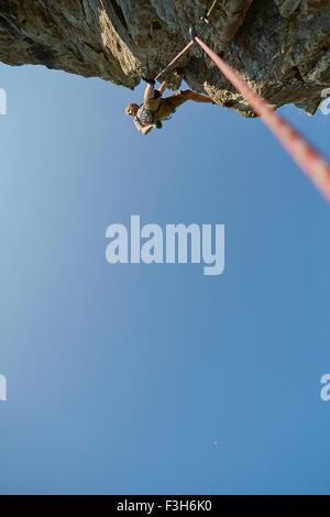 Low angle view of young male rock climber climbing rock formation, Val Senales, South Tyrol, Italy Stock Photo