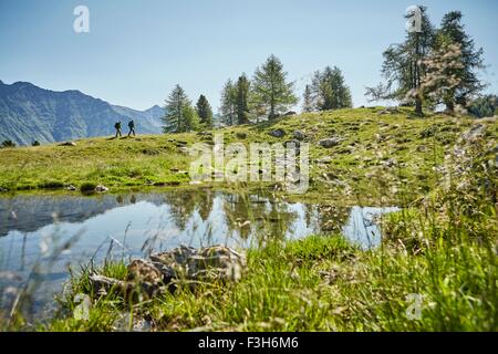 Young hiking couple in distant landscape, Karthaus, Val Senales, South Tyrol, Italy Stock Photo