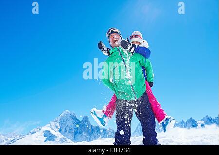 Father giving daughter piggyback ride, Chamonix, France Stock Photo