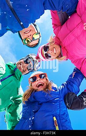 Low angle view of family in winter clothing and sunglasses Stock Photo