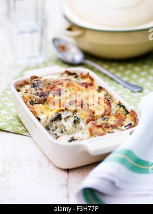 Still life of spinach and potato gratin in oven dish Stock Photo