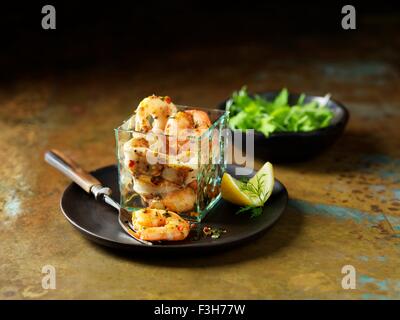 Still life of dressed king prawn and chargrilled calamari with bowl of mixed salad Stock Photo