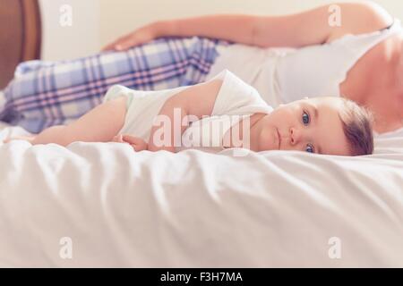 Mother and baby boy resting on bed Stock Photo