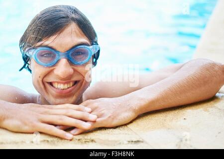 Portrait of young man wearing goggles in swimming pool Stock Photo