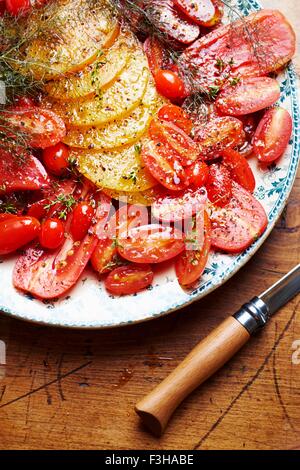 Selection of different types of tomatoes, sliced and seasoned, close-up Stock Photo