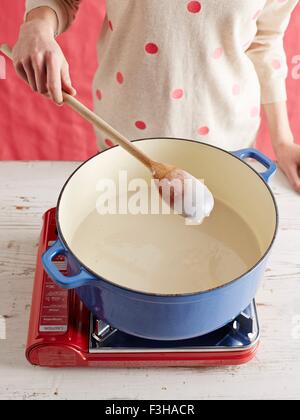 High angle view of mid adult womans mid section making gochuchang in a saucepan Stock Photo
