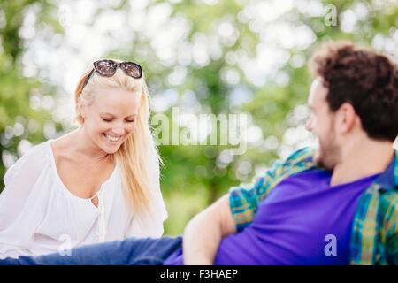 Couple relaxing outdoors talking and smiling Stock Photo