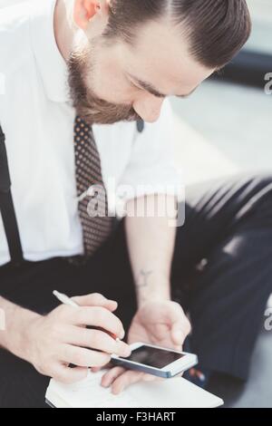 Businessman sitting cross legged outdoors meditating Stock Photo - Alamy