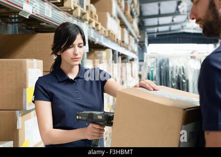 Warehouse workers using barcode scanner on box in distribution warehouse Stock Photo