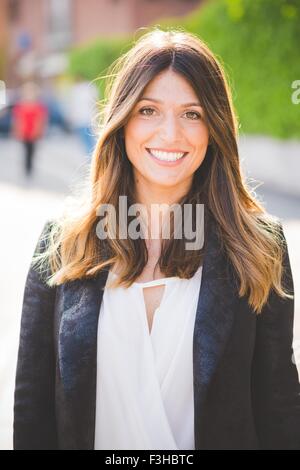 Portrait of happy young woman with long brown hair Stock Photo