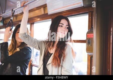 Two young women travelling on city tram Stock Photo