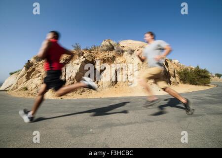 Two male friends, running, outdoors Stock Photo