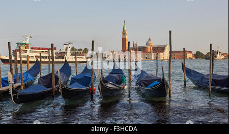 Gondolas moored on Venetian waterfront with San Giorgio Maggiore island and Basilica in background Venice Veneto Italy Europe Stock Photo