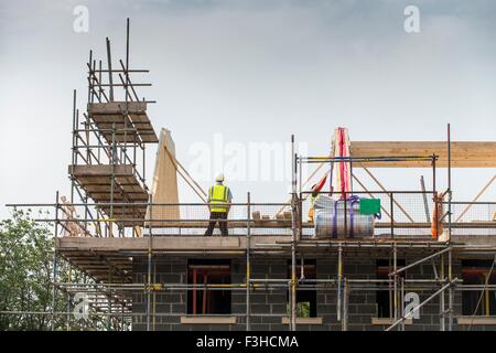 Worker working on roof of building Stock Photo