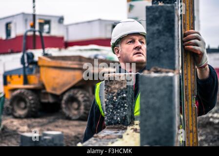 Workers laying bricks on construction site Stock Photo