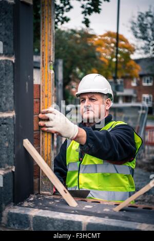 Workers laying bricks on construction site Stock Photo