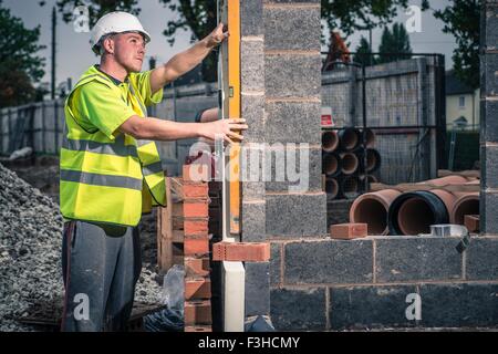 Workers laying bricks on construction site Stock Photo