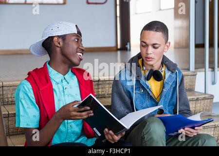 Students on steps, reading textbook Stock Photo